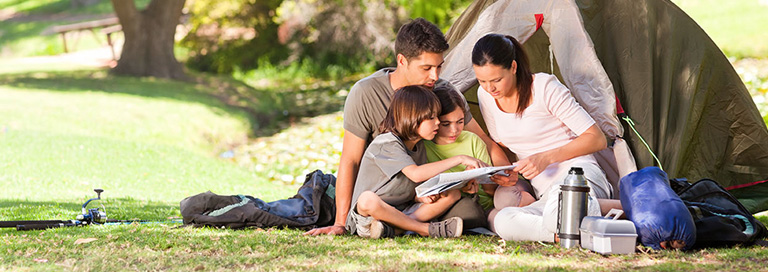 Family reading a map together while camping